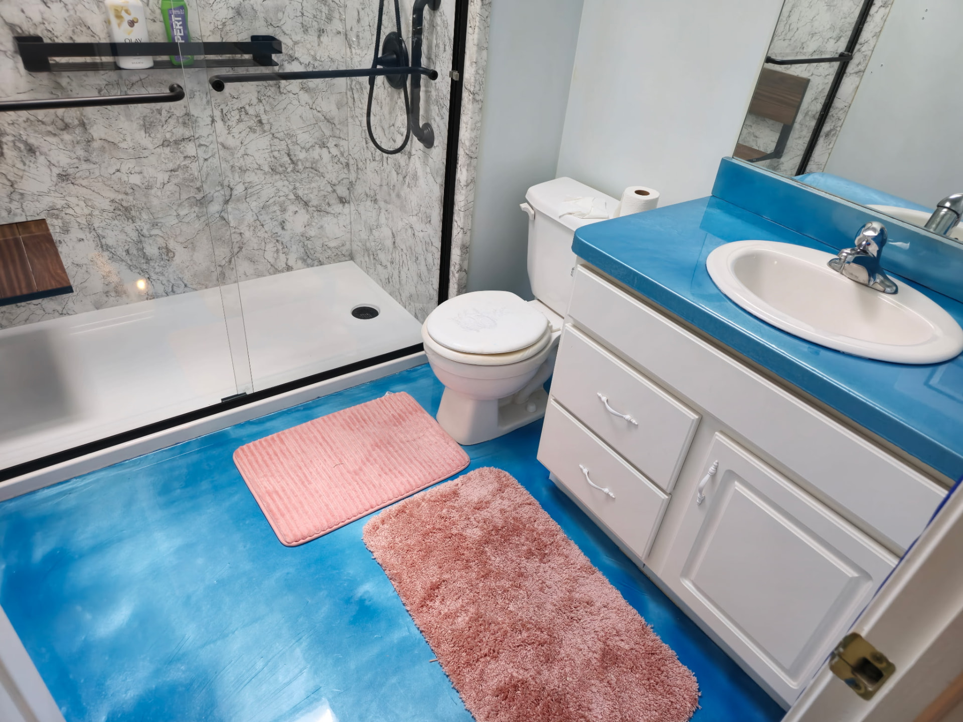 Blue metallic epoxy bathroom floor with a high-gloss finish