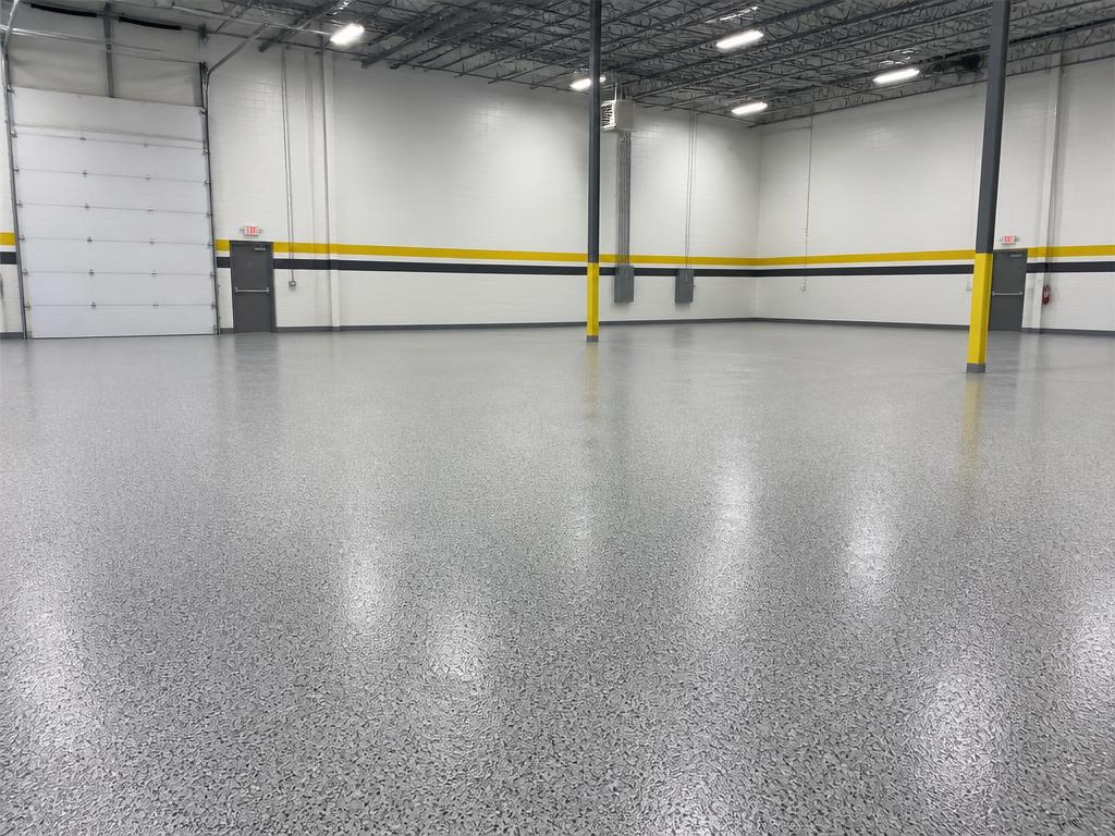 Grey warehouse epoxy floor with yellow and black safety striping